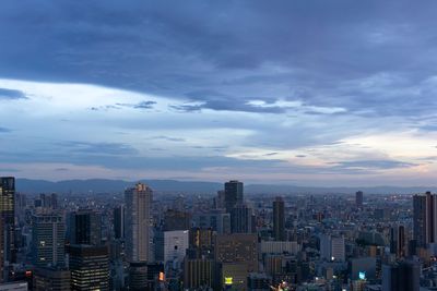 Modern buildings in city against sky during sunset