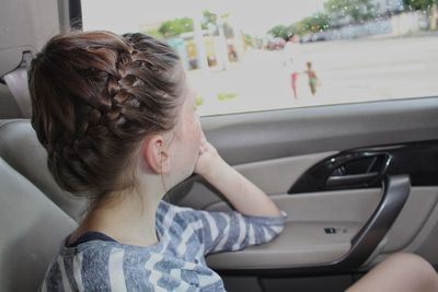 Rear view of woman sitting in car