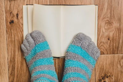 Low section of person wearing canvas shoes on wooden floor