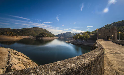 Scenic view of canal by town against sky