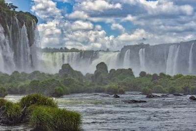 Scenic view of waterfall against sky