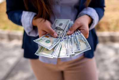 Midsection of woman holding banknotes