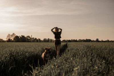 Young woman with dog on agricultural field