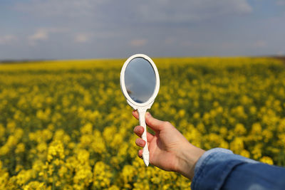 Midsection of man holding yellow flower