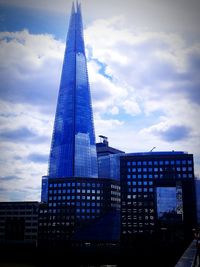 Low angle view of modern building against cloudy sky