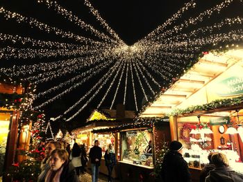 People at illuminated christmas lights at night