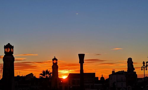 Silhouette buildings against sky during sunset