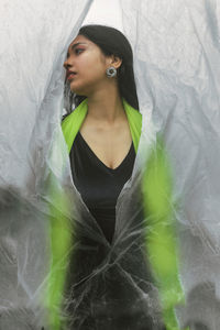 Portrait of beautiful woman standing against wall