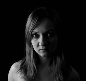 Close-up portrait of a beautiful young woman over black background