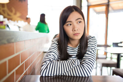 Portrait of a young woman sitting on table