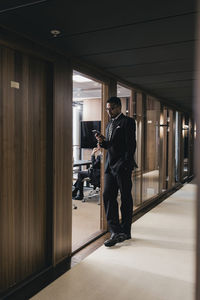 Side view of man standing in corridor of building