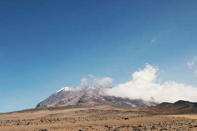 Barren landscape with mountain against sky