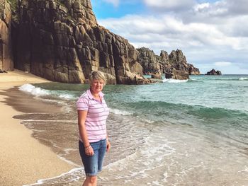 Full length of a man standing on rock at beach