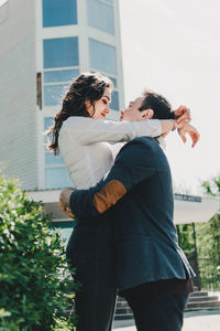 Rear view of man and woman standing against building