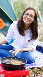 Portrait of a smiling young woman sitting on table