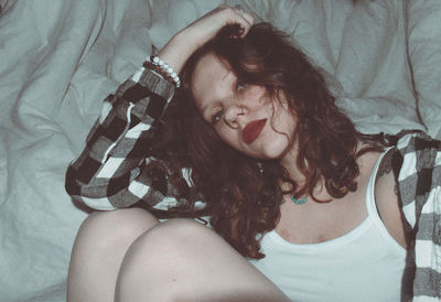 High angle portrait of woman lying on bed