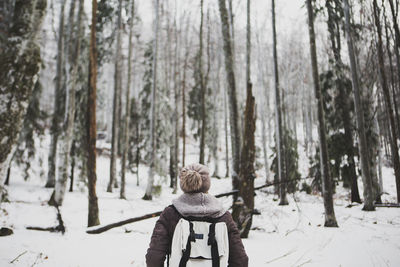 Rear view of person in forest during winter