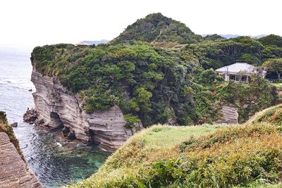 Scenic view of mountain by sea against clear sky