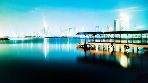 Illuminated buildings by city against sky at night