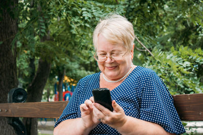 Mid adult woman using mobile phone outdoors