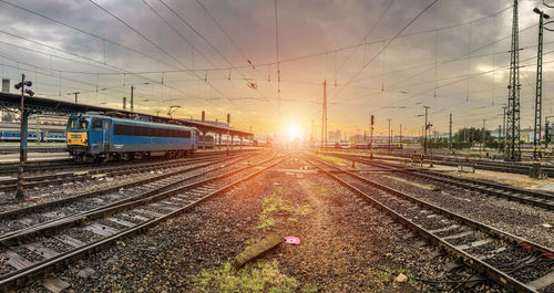 Railroad tracks against sky during sunset