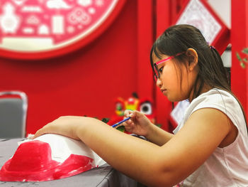 Close-up of cute girl painting craft product 