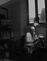 Side view of a man sitting at table