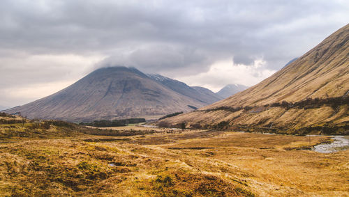 Scenic view of mountains against cloudy sky