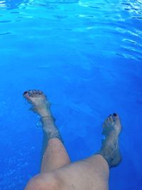 Low section of person swimming in pool