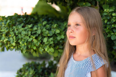 Portrait face of candid happy little kid girl of eight years old with long blond hair and green eyes