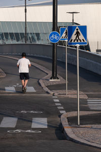 Rear view of woman walking on footpath