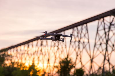 Low angle view of silhouette helicopter against sky during sunset