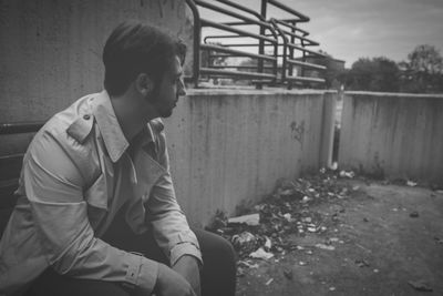 Side view of a man sitting outdoors