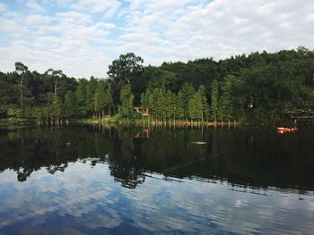 Scenic view of lake by trees against sky