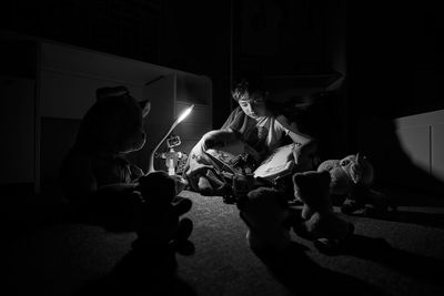 Boy reading book in darkroom