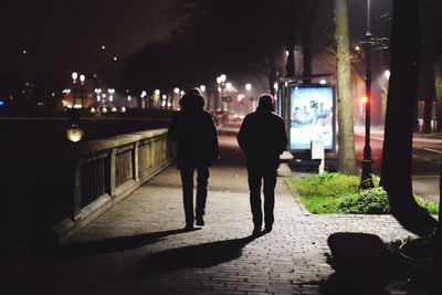 Rear view of men walking on street