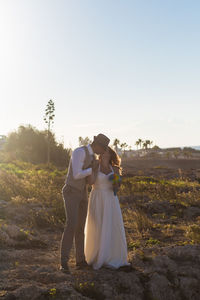 Couple holding umbrella against sky