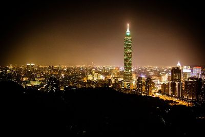 Illuminated cityscape against sky at night