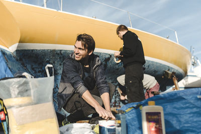 Friends preparing boat for painting