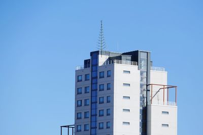 Low angle view of modern building against clear blue sky