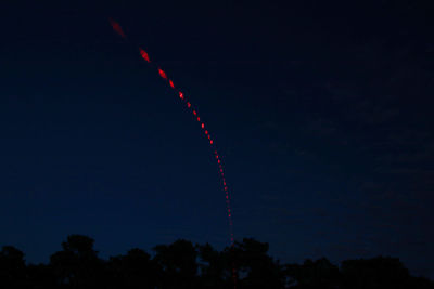 Low angle view of vapor trails in sky at night