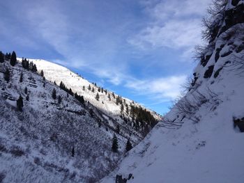 Low angle view of snow covered mountain against sky