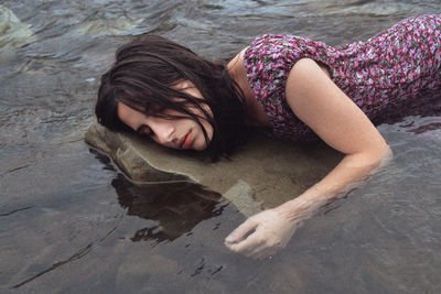 High angle view of woman lying in river