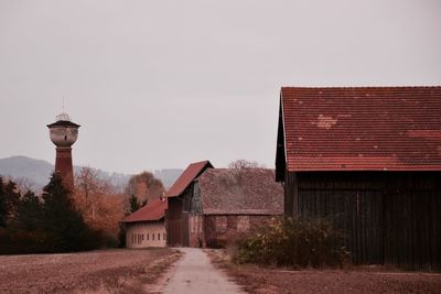 Old house by building against sky