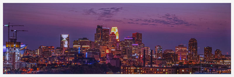 Illuminated buildings against sky at night