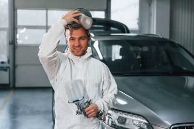 Job is done. man in uniform is working in the auto service.