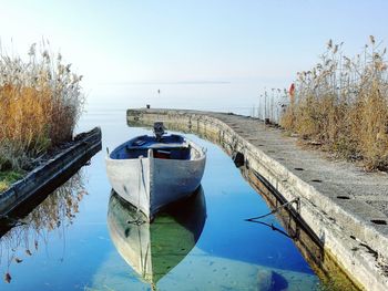 Boats moored in sea against clear sky