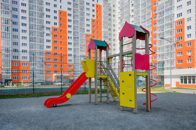 Empty playground against buildings in city