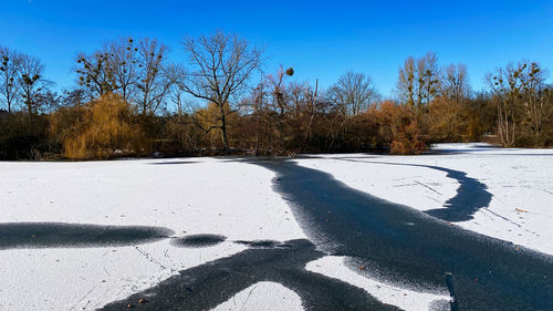 Scenic view of snow covered field against sky