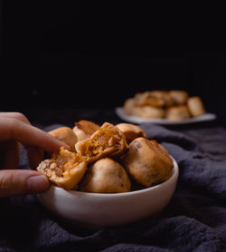 Close-up of hand holding bread in bowl